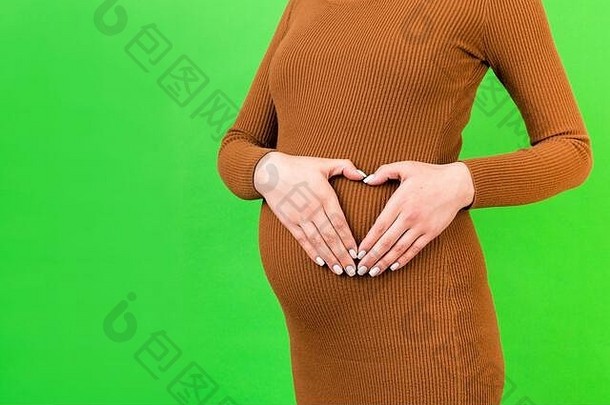 裁剪图像怀孕了女人使心形状手腹部绿色背景婴儿撞概念复制空间