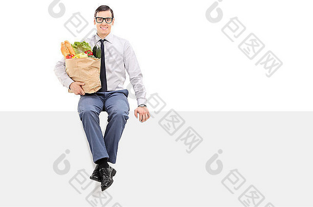 男人。持有袋食品杂货坐着面板孤立的白色背景