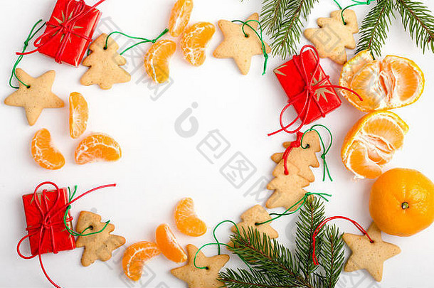 圣诞<strong>饼干</strong>、橘子和礼物的框架，以及用于节日文本的复制spase。从上面看白色桌子上的圣诞节手工装饰