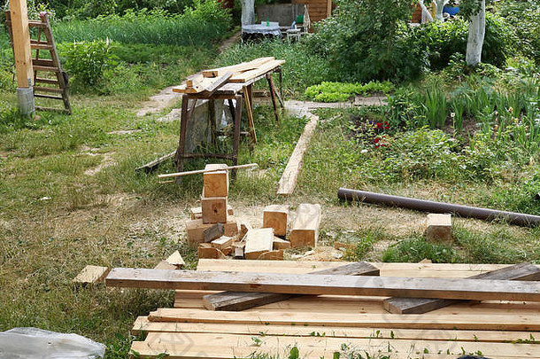 农村家庭非专业木匠的工作场所。<strong>锯</strong>开的木板躺在绿色的草坪上。夏日乡村景观