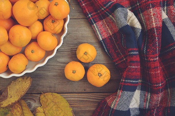 木制桌子和碗上新鲜柑橘的平面视图-秋季概念