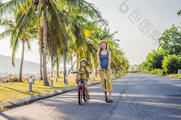 活跃的学校孩子男孩妈妈安全头盔骑自行车背包阳光明媚的一天快乐孩子骑自行车<strong>学校安全</strong>孩子们