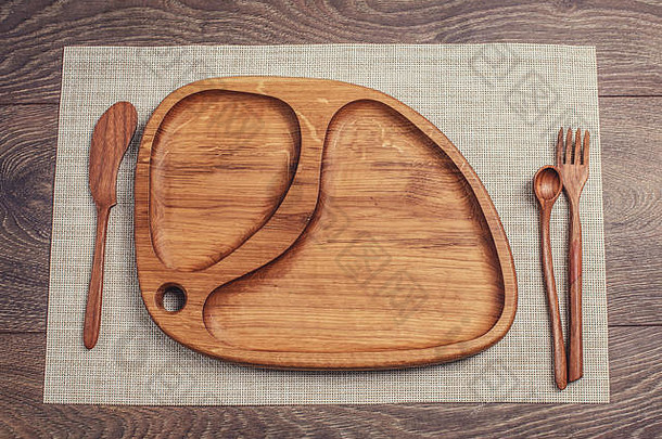 带刀、勺和叉的木制盘子。