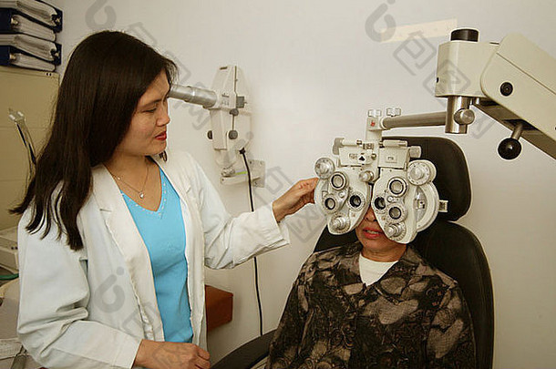 验光师<strong>检查</strong>病人的视力越南裔美国社区医疗诊所花园格罗夫加州美国
