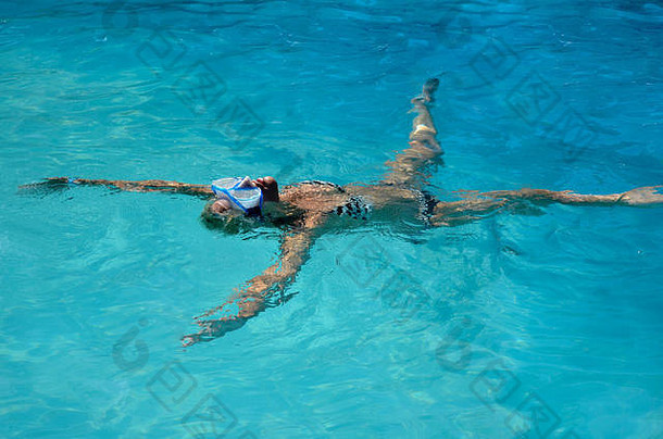 年轻的金发碧眼的高加索人白色女人穿着条纹比基尼浮动游泳池高角视图夏天假期时间