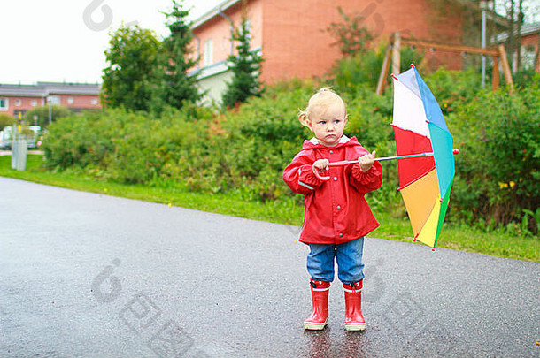 雨天带着雨伞的蹒跚学步的女孩