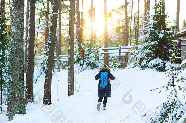 年轻女子在白色的冬季森林里徒步旅行。生活方式概念