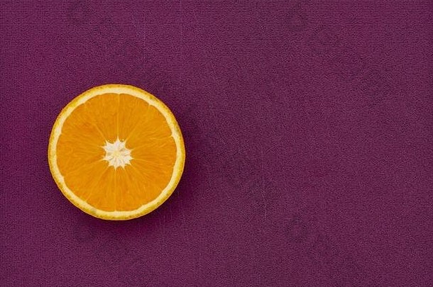 紫色背景上半橙色水果的俯视角