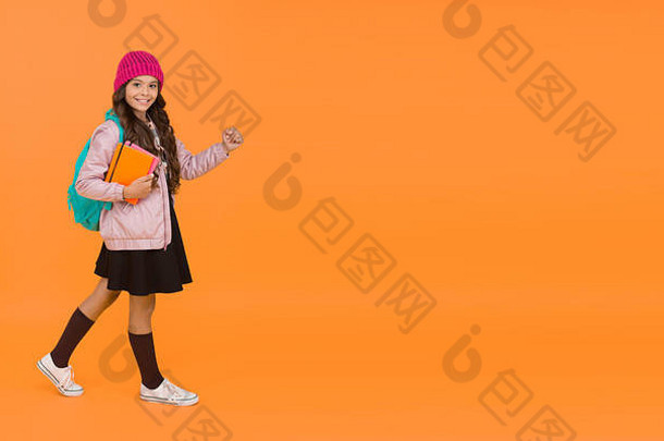 学校回来了。快乐的孩子回到学校。小女孩上学橙色背景。回到教室。九月一号。欢迎回到秋天，空间。