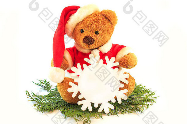 戴着圣诞老人帽子的玩具泰迪熊，在白色背景上孤立，手里拿着雪花