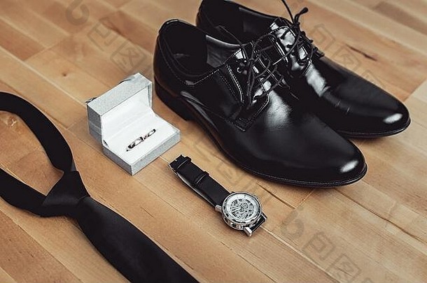 现代新郎配饰的特写镜头。结婚戒指、黑领带、皮鞋和手表