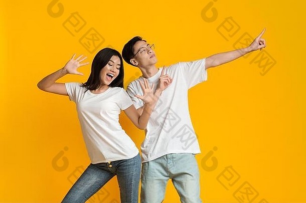 情绪化的亚洲男女在黄色背景下跳舞