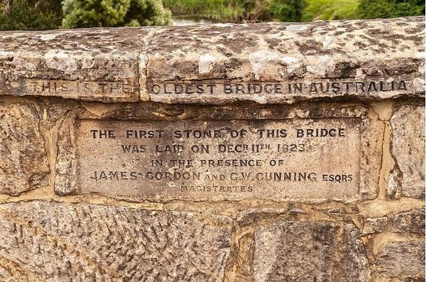 里士满，塔斯马尼亚州，澳大利亚-2009年12月13日：煤河上的棕色石头历史桥上的铭文特写，带有。，把它命名为最古老的b