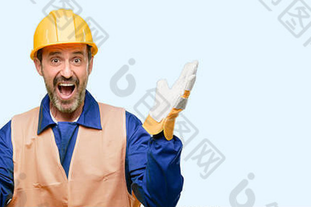 高级工程师男子，建筑工人高兴和惊讶的欢呼声，在蓝色背景上表示惊奇的手势
