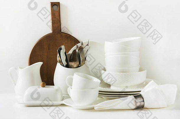 白色餐具。白色桌面上的陶器、盘子、器皿和其他不同的白色物品。厨房静物作为背景。空间。