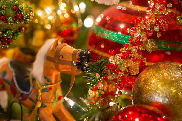 摇马玩具特写镜头和作为圣诞树装饰悬挂的闪闪发光的圣诞饰品，背景上闪烁着光晕