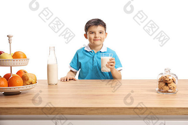 可爱的男孩蓝色的t恤持有玻璃牛奶木计数器孤立的白色背景