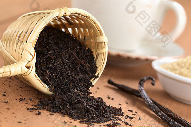 散装红茶装在木制茶叶注射器中，配香草棒、红糖和茶杯
