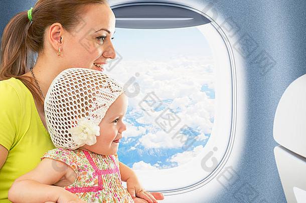 快乐的妈妈和孩子一起在靠近窗户的机舱里旅行