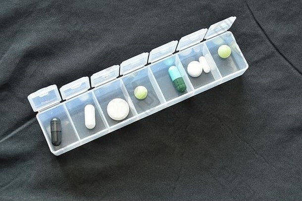 黑色布上塑料药筒中的药物和药丸