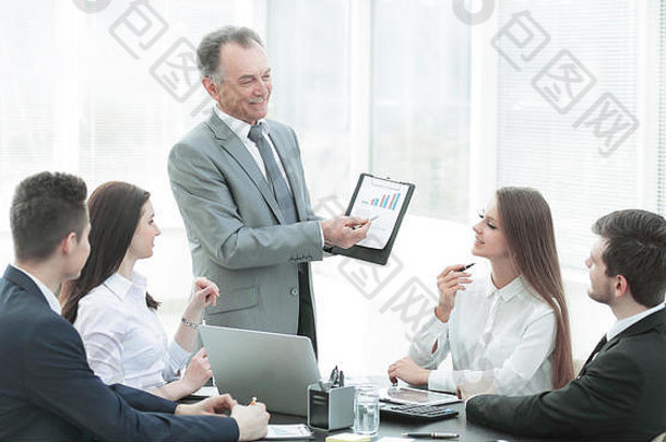微笑的经理展示一个业务团队，一个包含财务数据的图表。