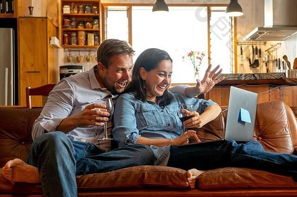 在家生活幸福夫妻<strong>视频</strong>通话的朋友和家人使用笔记本电脑的图像。网上聊天的男人和女人在虚拟的庆祝会上用<strong>酒</strong>喝彩