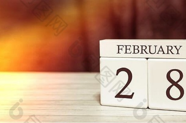 日历提醒事件概念。2月28日阳光照射下的带数字和月份的木制立方体。