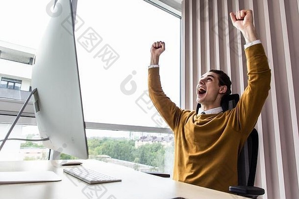 兴奋的企业家在办公室的工作场所使用个人电脑在线阅读好消息
