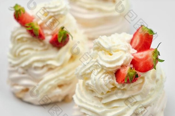 在白色背景上用草莓和鲜奶油特写美味的蛋白酥皮。安娜·巴甫洛娃甜点。