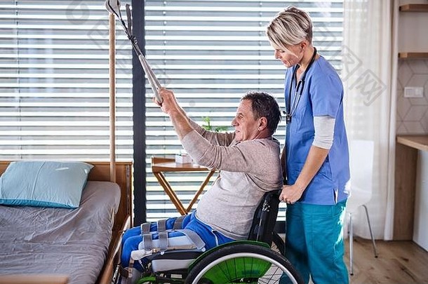 一名<strong>医护人员</strong>和一名<strong>坐</strong>轮椅的老年患者，接受物理治疗。