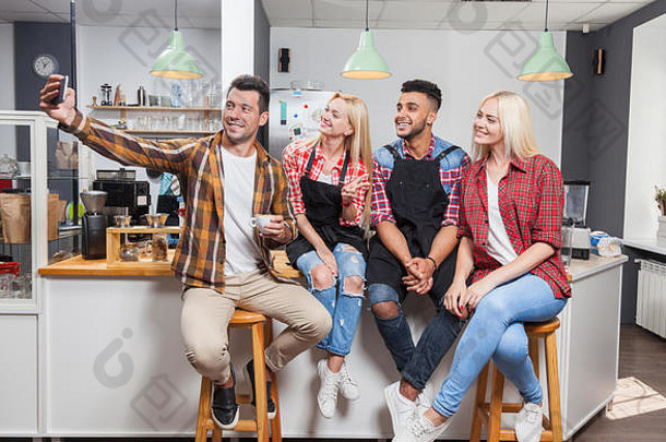 人采取自拍朋友图片喝咖啡商店咖啡师坐着酒吧计数器混合比赛但持有聪明的电话女人快乐微笑