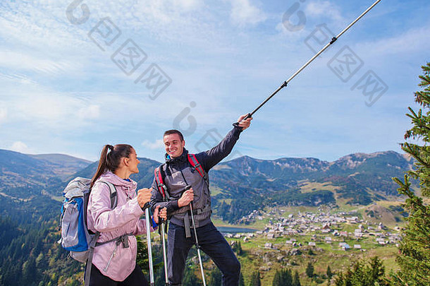 两个徒步旅行者带着登山杖在山顶上路