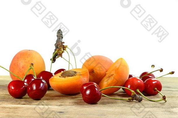 新鲜水果樱桃和杏子放在木桌上。