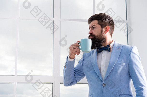 男人新郎一大早就喝咖啡。伟大一天的开始。他生命中重要的一天。准备好。享受每一分钟。穿着燕尾服、打着领结、啜饮咖啡的时髦人士。但首先是咖啡。