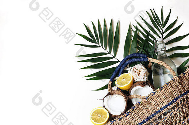 <strong>夏季</strong>静物画的构图包括草篮袋、茂盛的棕榈叶、柠檬、椰子和白色背景上的玻璃瓶水