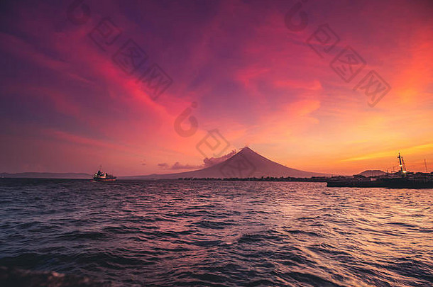 吕宋岛上的大马荣火山全景。东方的山峰和美丽的彩色天空夕阳。用船在海上摄影。菲律宾海滨生态区风光