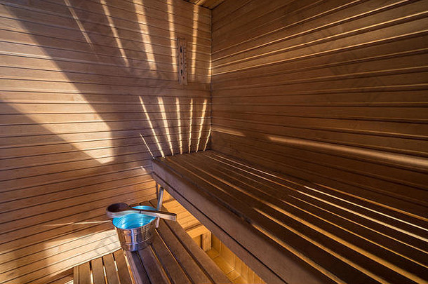 健康水疗中心概念桑拿浴桶蓝色的水独家新闻条纹光木墙木材板凳上