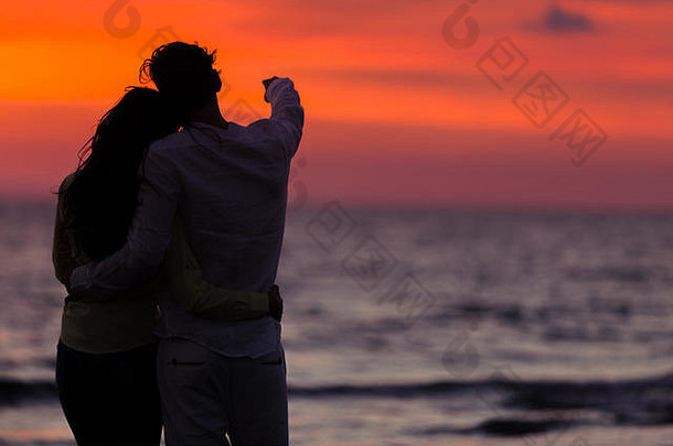 年轻<strong>情侣</strong>在海滩拥抱的夕阳剪影