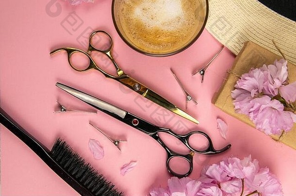 理发工具-剪刀、梳子和粉色花朵，粉色背景上有咖啡。美的概念。平面布置，俯视图