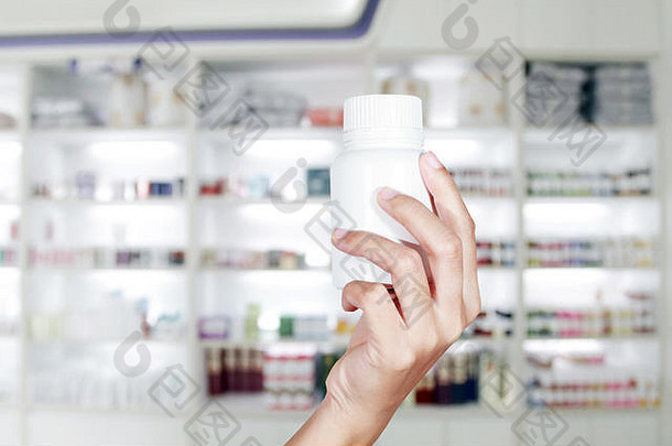 医生手拿药瓶放在药柜上，存放药品和药房