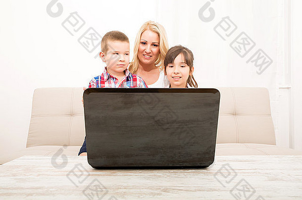一位母亲与她的儿子和女儿一起使用笔记本电脑。