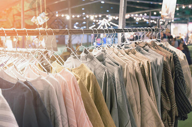 密切关注服装市场零售店挂在衣架上的不同设计的手工棉质女式衬衫。