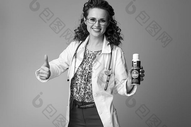 微笑儿科医师女人白色医疗袍显示拇指昆虫令人讨厌的背景