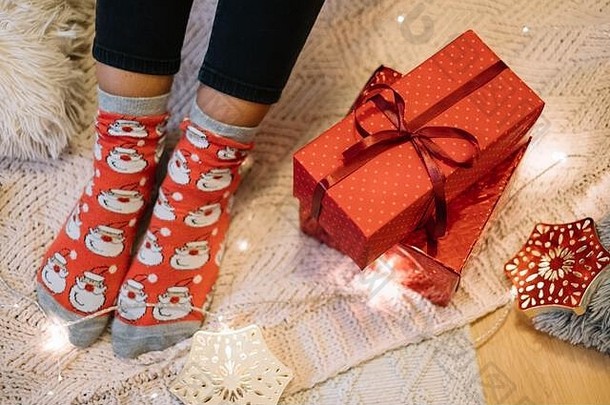 针织毛毯上有圣诞老人袜子的女人腿