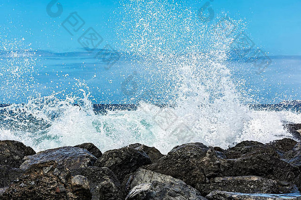 潮汐波在海岸的石头上形成了<strong>小水花</strong>
