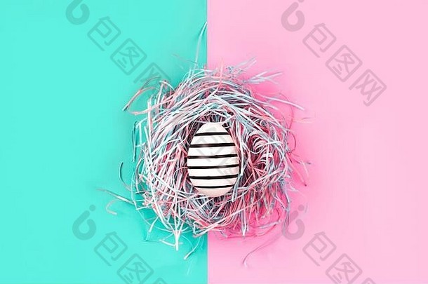 蓝色和粉色粉彩背景上装饰巢中的图形手绘线蛋。复活节的概念。