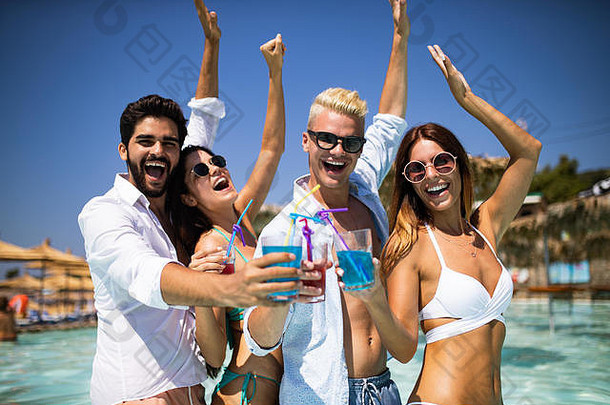 夏日派对。海滩上的朋友们喝着鸡尾酒，玩得很开心