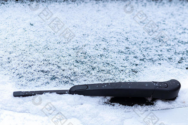 带雨刷的车窗被雪覆盖，微距，特写。没有使用防冻剂。雪地里的车辆。冬天快到了。<strong>恶劣</strong>的<strong>天气</strong>条件