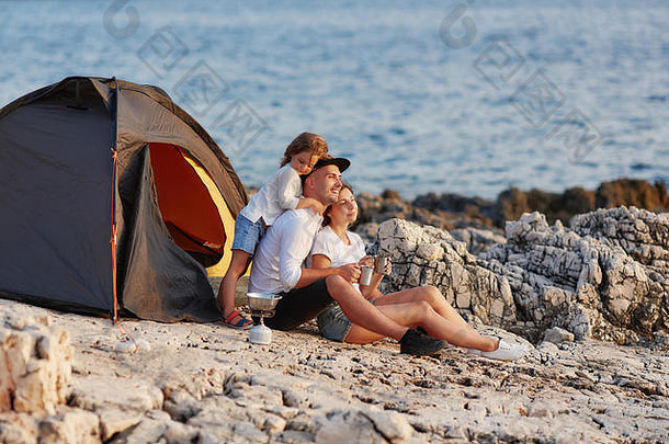 友好的真诚的家庭休息岩石海滩帐篷