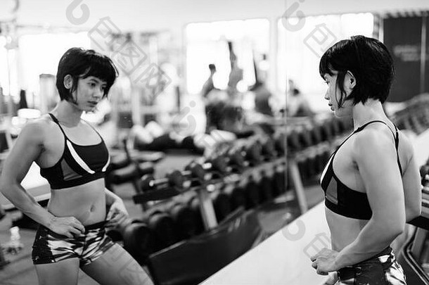 年轻的美丽的亚洲女人工作健身房